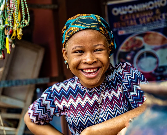 A market trader smiling at her stall